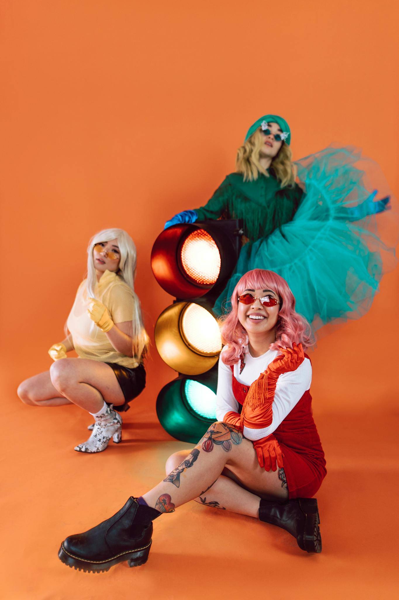 Three friends in colorful retro outfits enjoy a fun costume party.